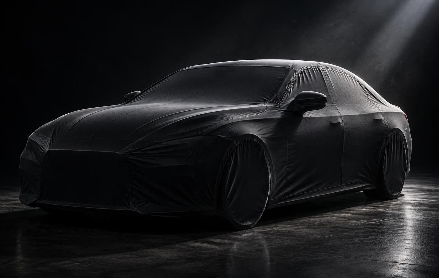 A sedan wearing its fitted Auto Armor cover, seams tracing the car's body lines under a single rim light